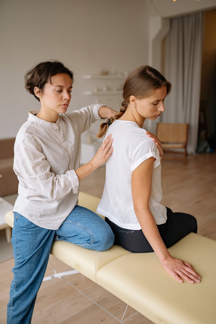 A relaxing therapeutic massage session between two women inside a modern spa.